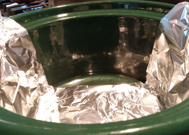 To make enchiladas in a slow cooker, you first need to make a sling with foil.